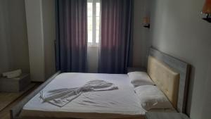 un letto vuoto in una camera da letto con finestra di Veal Hotel and Restaurant a Tepelenë