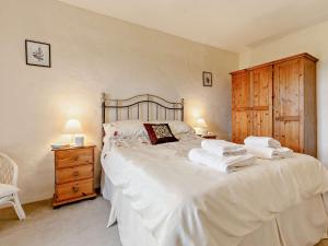 1 dormitorio con 1 cama blanca grande y toallas. en 3 Bed in Falmouth CONWI, en Constantine