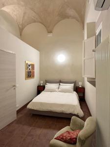 um quarto com uma cama e uma cadeira em Appartamento L'antica colonna, in centro storico em Parma