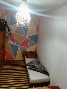 um pequeno quarto com uma cama e um lustre em Ocean Jam Surf House em Agadir