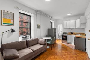 een woonkamer met een bank en een keuken bij 89-3FS Newly Furnished 2br 1bath UES in New York