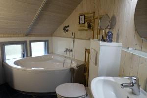 een badkamer met een bad, een toilet en een wastafel bij Dänisches Ferienhaus in Kaltenhof