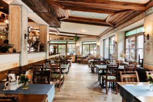 un restaurante con mesas, sillas y ventanas en Hotel Schlof Guat en Oberpullendorf