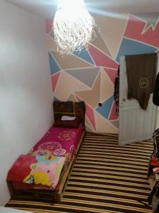 a room with a bed and a geometric wall at Ocean Jam Surf House in Agadir