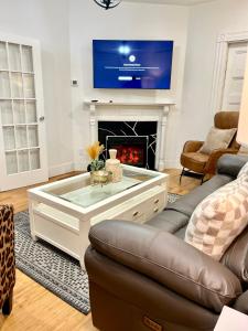 a living room with a couch and a fire place at Harvrd-MIT-B.U./Parkfree/Single Family residence in Boston