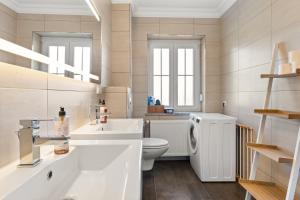 a white bathroom with a toilet and a sink at YUVA HOMES am Kurpark in Bad Wörishofen +55 photos