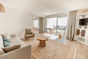a living room with a couch and a table at Hôtel Les Corallines - Thalasso & Resort in La Grande Motte