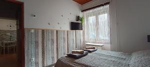 a bedroom with a bed and a window at Kis kuckó in Tapolca