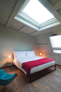 ミラノにあるMilan Design Suitesのベッドルーム(ベッド1台、天窓付)