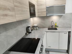 a kitchen with white cabinets and a sink at Premium&Cozy Two Beds DHA in Lahore