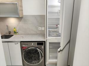 a kitchen with an empty refrigerator and a washing machine at Premium&Cozy Two Beds DHA in Lahore