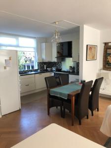 eine Küche und ein Esszimmer mit einem Tisch und Stühlen in der Unterkunft Our home, your home, close to Amsterdam in Nederhorst den Berg