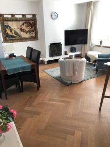 a living room with a wooden floor and a tv at Our home, your home, close to Amsterdam in Nederhorst den Berg