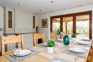 a dining room with a table with wine glasses at Serene Riverside: 6BR Luxury Retreat in Curdridge in Curdridge