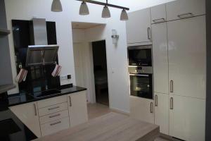 a kitchen with white cabinets and black counter tops at Ferienwohnung Skandianvian Sol in Zinnowitz
