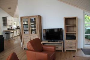 a living room with a television and a chair at Ferienwohnung Skandianvian Sol in Zinnowitz +6 photos