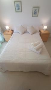 - un grand lit blanc avec deux lampes au-dessus dans l'établissement El bon repòs del delta, à El Lligallo del Gànguil