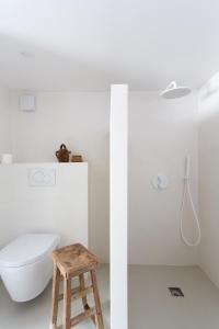 a bathroom with a toilet and a stool at PYLA: Nice creative studio 200 m from the beach in La Teste-de-Buch
