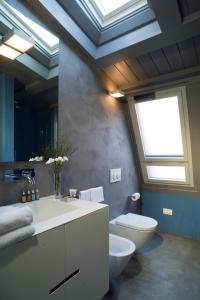 a bathroom with a sink and a toilet and a skylight at Milan Design Suites in Milan