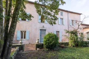 an old pink house with blue shutters and a tree at Maison coeur de Bastide-Piscine, ping pong & salle de jeux in Vianne