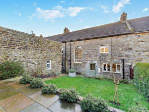 an exterior view of a stone house with a yard at 3 Bed in Leyburn G0185 in Carlton