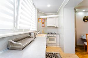 una cocina con armarios blancos y una ventana en 2 room apartment in the center city, en Chişinău