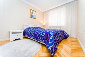 1 dormitorio con 1 cama con manta azul en 2 room apartment in the center city, en Chişinău