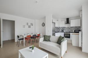 een woonkamer met een witte bank en een tafel bij Chic and spacious apart with parking in Cergy