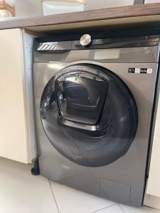 a washing machine with its door open under a counter at InselSuites FinkenNest Airbus Finkenkwerder 125 m2 Kamin Whirpool in Hamburg