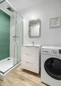 a bathroom with a washing machine and a shower at Platinium Zaspa - Pilotów 14 in Gdańsk
