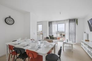 a white dining room with a table and chairs at Chic and spacious apart with parking in Cergy