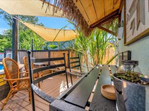 een houten tafel op een terras met stoelen en een hangmat bij Luxury Couples Villa with private pool in Largo