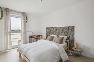 een witte slaapkamer met een groot bed en een raam bij Chic and spacious apart with parking in Cergy