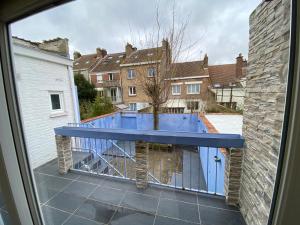 uma vista para uma varanda com um banco azul em Maison malouine proche de plage em Dunkerque