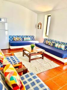 een woonkamer met blauwe banken en een tafel bij Resort Albufeira T1, Praia da Oura in Albufeira