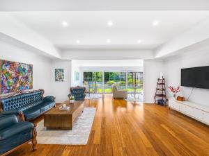 a living room with a couch and a tv at Modern 5Bedroom House w Outdoor Pool Robertson in Brisbane