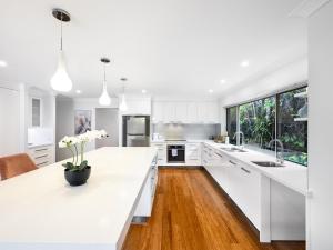 eine Küche mit weißen Arbeitsflächen und einer großen weißen Arbeitsplatte in der Unterkunft Modern 5Bedroom House w Outdoor Pool Robertson in Brisbane