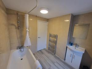 a bathroom with a tub and a sink at Central 5BR Retreat - Walk to Tube, Explore London in London