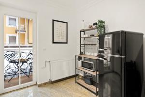 a black refrigerator in a room with a balcony at YUVA HOMES am Kurpark in Bad Wörishofen