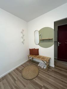 une chambre avec un banc, un miroir et une porte dans l'établissement Hana Home T2 Guyancourt, à Guyancourt