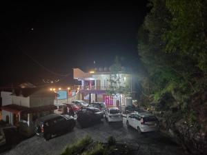 un grupo de autos estacionados en un estacionamiento por la noche en SH SUNSET RESORT en Nainital