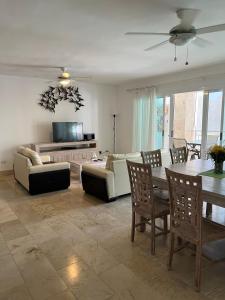 ein Wohnzimmer mit einem Sofa, einem Tisch und Stühlen in der Unterkunft Bello y cómodo apartamento, frente al mar in Punta Cana