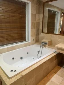 eine große Badewanne im Bad mit Fenster in der Unterkunft Bello y cómodo apartamento, frente al mar in Punta Cana