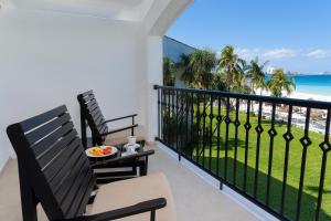 uma varanda com 2 cadeiras e vista para a praia em Beachscape Kin Ha Villas & Suites em Cancún