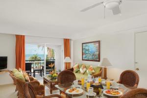 een woonkamer met een tafel en stoelen bij Beachscape Kin Ha Villas & Suites in Cancun