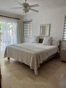 Schlafzimmer mit einem Bett und einem Deckenventilator in der Unterkunft Bello y cómodo apartamento, frente al mar in Punta Cana