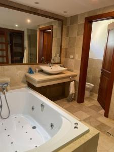 ein großes Bad mit einer Badewanne und einem Waschbecken in der Unterkunft Bello y cómodo apartamento, frente al mar in Punta Cana