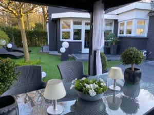 a patio table with two lamps and flowers on it at Bed & Breakfast Romee in Epe