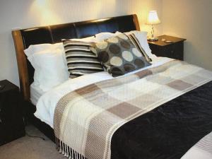 - un lit avec des oreillers et une couverture dans l'établissement Holiday Cottage Cornwall, à Delabole