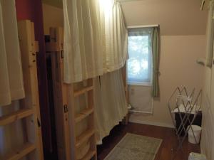 a room with a book shelf and a window at Bellscabin Guesthouse in Karuizawa